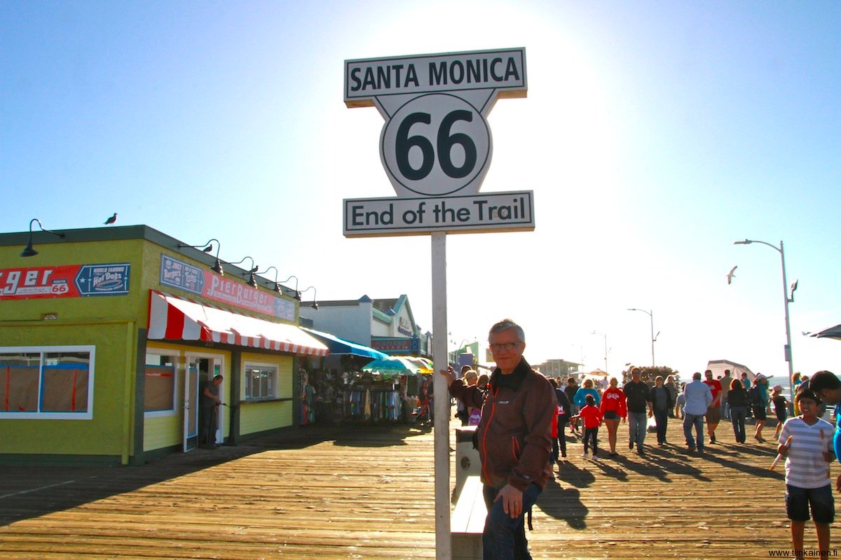 Vesa at the End of Trail 66 sign in Santa Monica Pier California